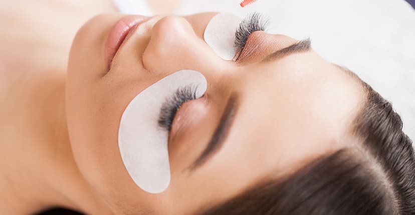 Women laying down receiving a lash and brow treatment Women laying down receiving a lash and brow treatment